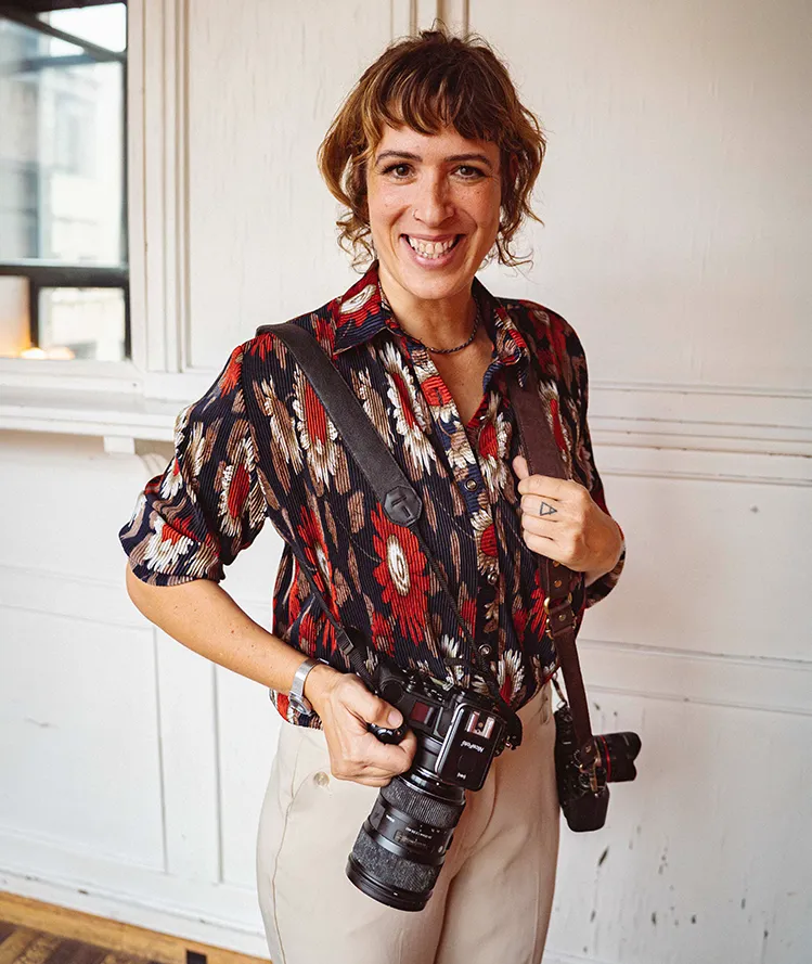 Henriette Becht mit Kameras über der Schulter, lächelnd